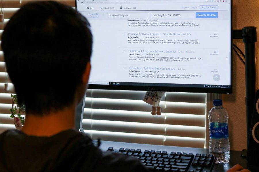 Steve Zhu, junior in Engineering, searches through the Los Angeles Times classifieds page for employment opportunities after graduation. 