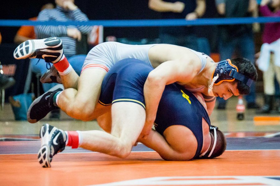 Illinois Isaiah Martinez wrestles with Michigans Logan Massa in the 165 pound weight class during the match at Huff Hall on Friday, January 20. Martinez won by decision and the Illini defeated the Wolverines 34-6.