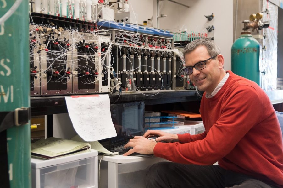 Professor Martin Burton poses  with his molecular making machine at the Roger Adams Laboratory.