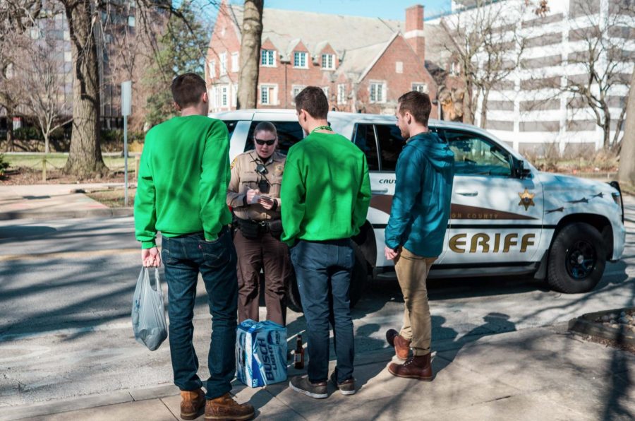 A police officer issues tickets hear Fifth Street in the morning of Unofficial St. Patrick’s Day. Students have privacy rights they can enforce this Unofficial.