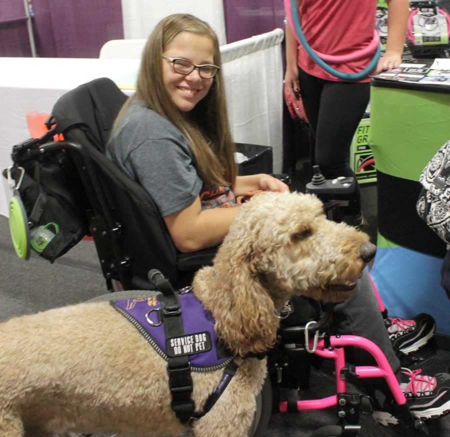A person in a wheelchair poses for a photo during the disABILITY Resource Expo in 2017.