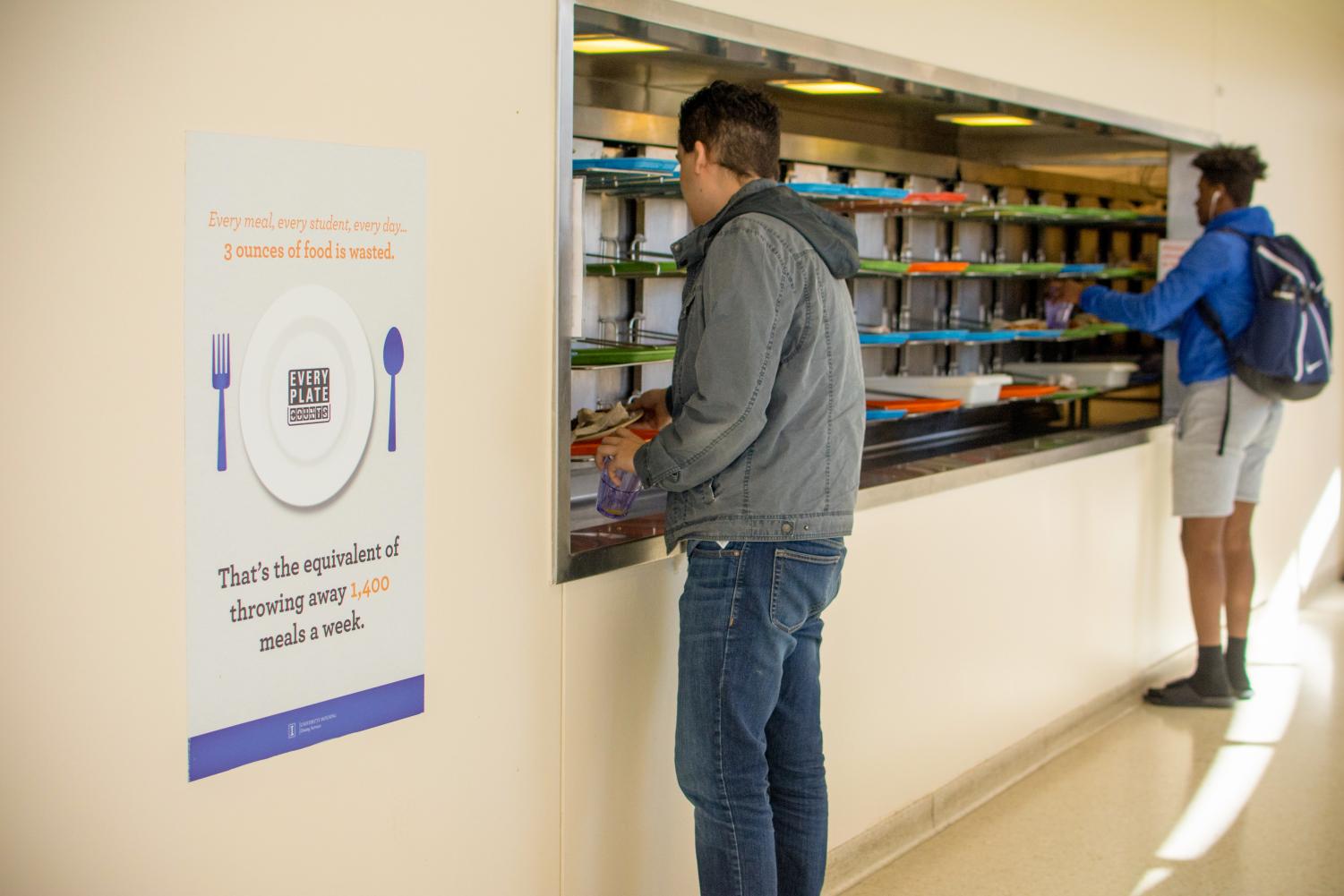 Students place their used utensils and plates in the conveyor belt for cleaning after their meals at the Ikenberry Dining Hall.