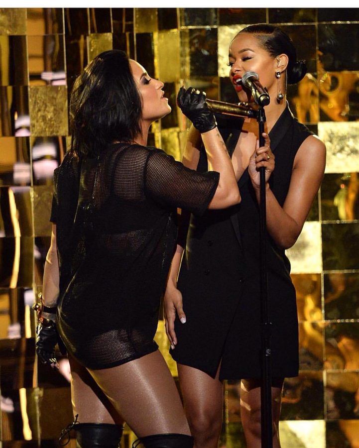 Charity Davis and Demi Lovato performing onstage during one of Lovatos tour events.  