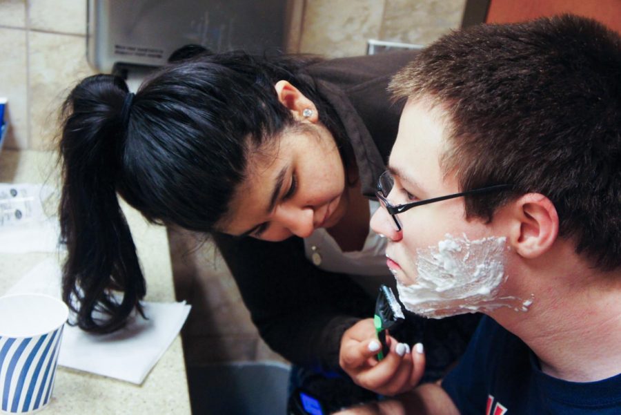 Charmaine Gutierrez helps Aaron Brannen shave his face during one of her morning shifts. Some students with disabilities on
campus choose to hire their own personal assistants to help them with their daily tasks.