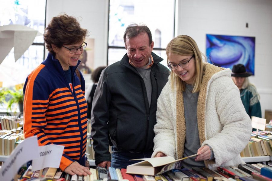 Madeleine Brown, president of the Books to Prisoners RSO, helps Renee and Neal Brown find books at the group’s book sale at the Independent Media Center on Nov. 3. The RSO, which started as a local nonprofit organization, aims to provide incarcerated individuals with access to reading material.