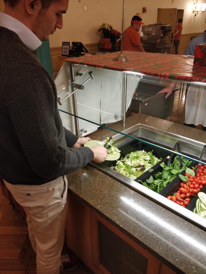 Lorenzo Molinari, junior in LAS, takes lettuce from the salad
bar at Illini Union Dining Hall on Monday. Romaine lettuce has been taken off menus due to a recent E. coli outbreak.