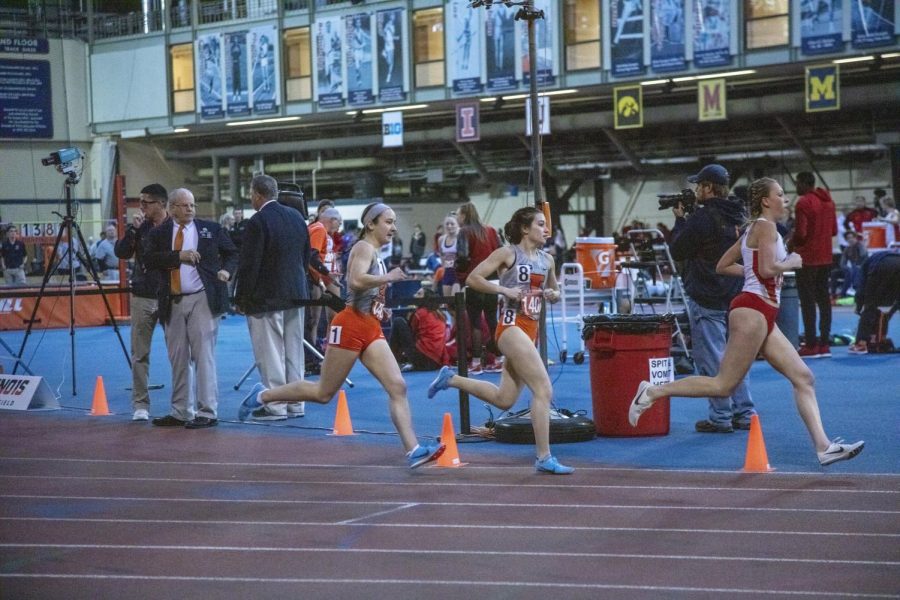 Madison Marasco (1) and Rebecca Craddock (8) run in the 1-mile event on Jan. 26 at the Armory. Head coach Michael Turk was inducted into the Illinois Athletics Hall of Fame in April.