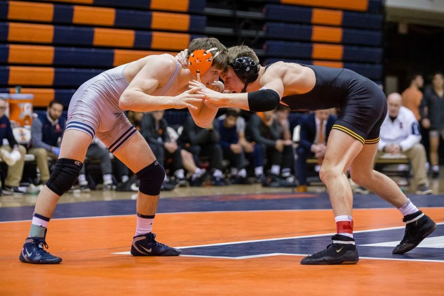 Illinois Mike Carr wrestles with Iowas Max Murin in the 141-pound match at Huff Hall on Friday, Jan. 25, 2019. The Illini lost 31-8.
