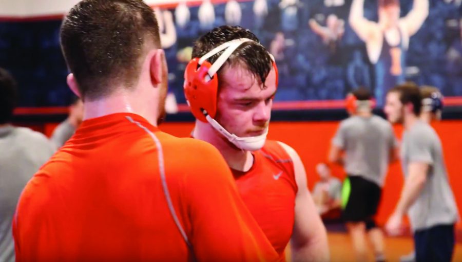 The Braunagel twins talk during a break in practice at the Wrestling practice space at Huff Hall. The two brothers decided to attend the University after each having a successful high school campaign.