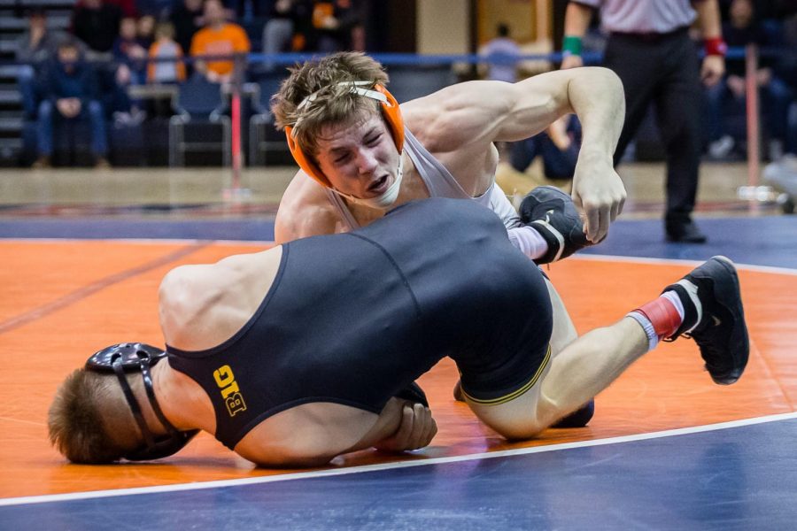 Illinois’ Mike Carr wrestles with Iowa’s Max Murin in the 141-pound match at Huff Hall on Jan. 25. The Illini lost 31-8.