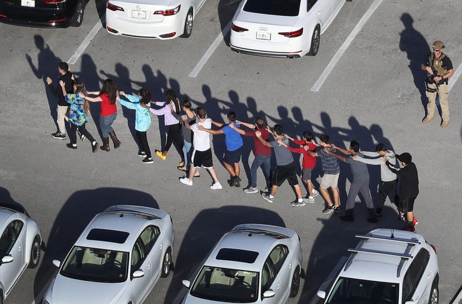 People are brought out of the Marjory Stoneman Douglas High School after a shooting at the school that reportedly killed and injured multiple people on February 14, 2018 in Parkland, Florida. Numerous law enforcement officials continue to investigate the scene.