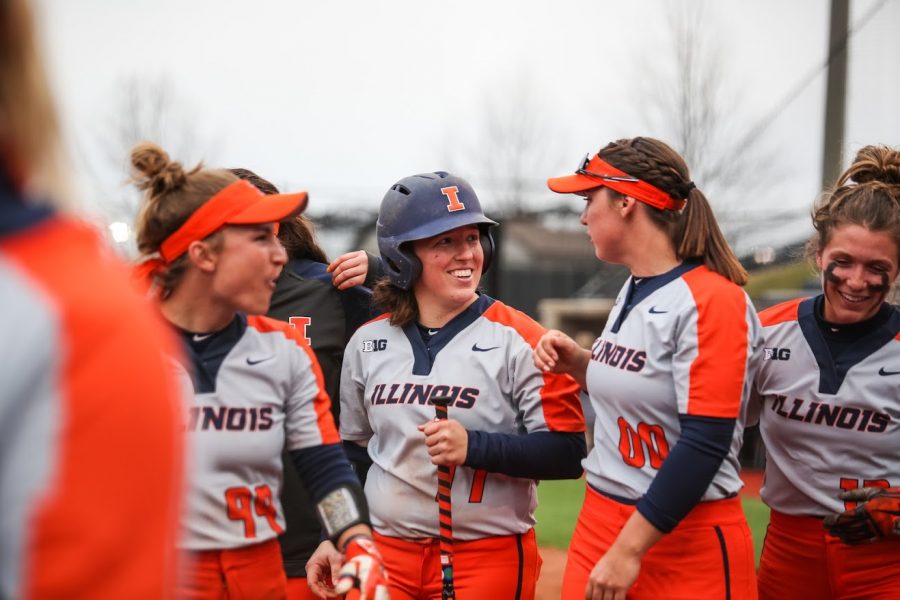 Serenity Stewart (center) gets congratulated by her team for hitting a home run at Eichelberger Field on Wednesday. The Illini beat the Redbirds 2-1.