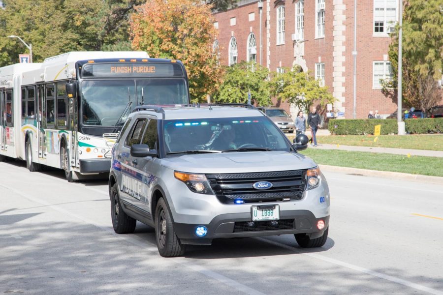 A University of Illinois campus police vehicle follows the Marching Illini as they march through the streets for Homecoming on Oct. 13. Craig Stone, chief of police at the University, said they have developed a reaction plan for threats of gun violence. 