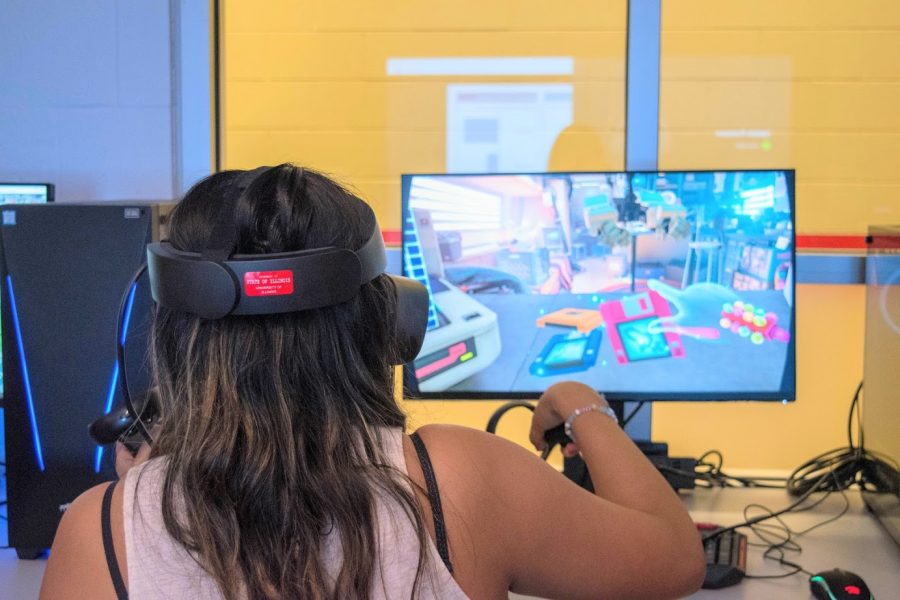 Nancy Torres, junior in Business, explores the capabilities of the virtual reality headset as she plays one of the interactive games on the computer in the Virtual Reality Lab at the Armory on Oct. 2. It is being debated whether VR technology assists in learning and should be implemented in classrooms.