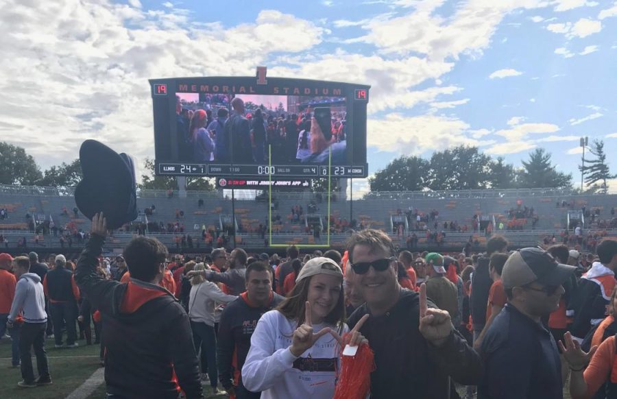 Meghan Lyons and her father celebrate on the field of Memorial Stadium after the historic win against Wisconsin during the Homecoming game Oct. 19. Lyons encourages students to show appreciation for their dads this Dads Weekend.