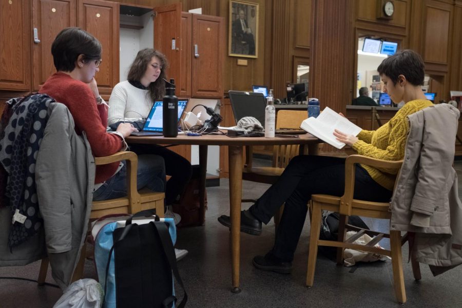 Three students study together on the second floor of the Main Library on Tuesday. Many students face heavy workloads and study during finals season. 