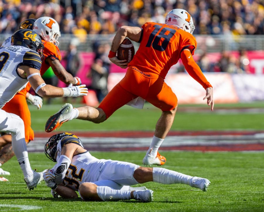 Graudate transfer quarterback Brandon Peters jumps over a California defender during the Redbox Bowl on Monday. Illinois fell to California 35-20 in the teams first bowl game since 2014. 
