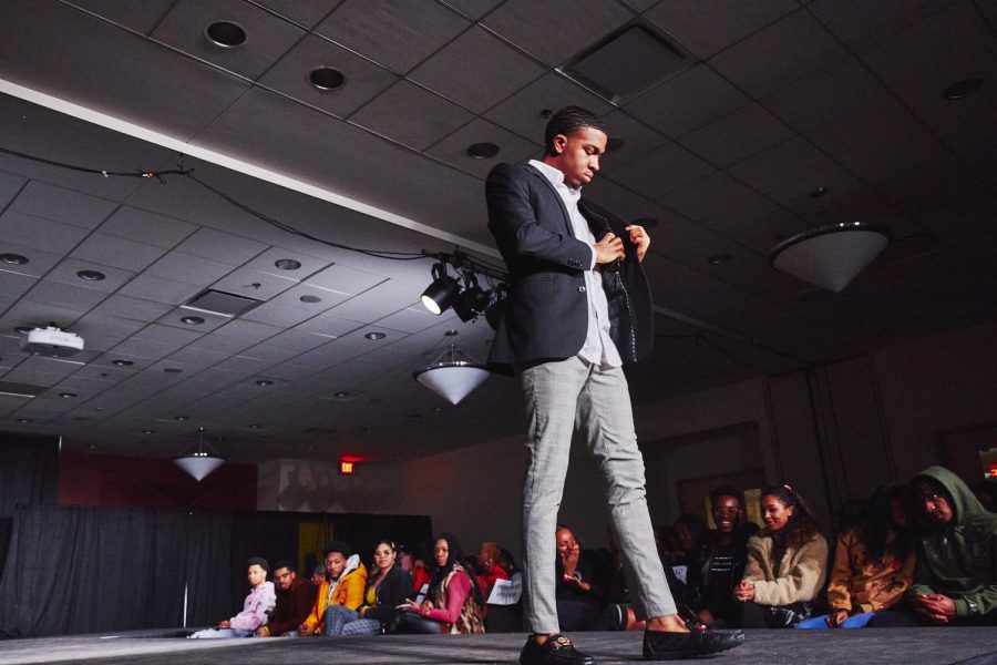A model checks his pocket and walks down the runway at the Cotton Club Fashion Show hosted by the Central Black Student Union at the Student Dining and Residential Programs Building on Friday. Cotton Club Week, a series of events intended to showcase and celebrate black excellence, took place on campus last week.