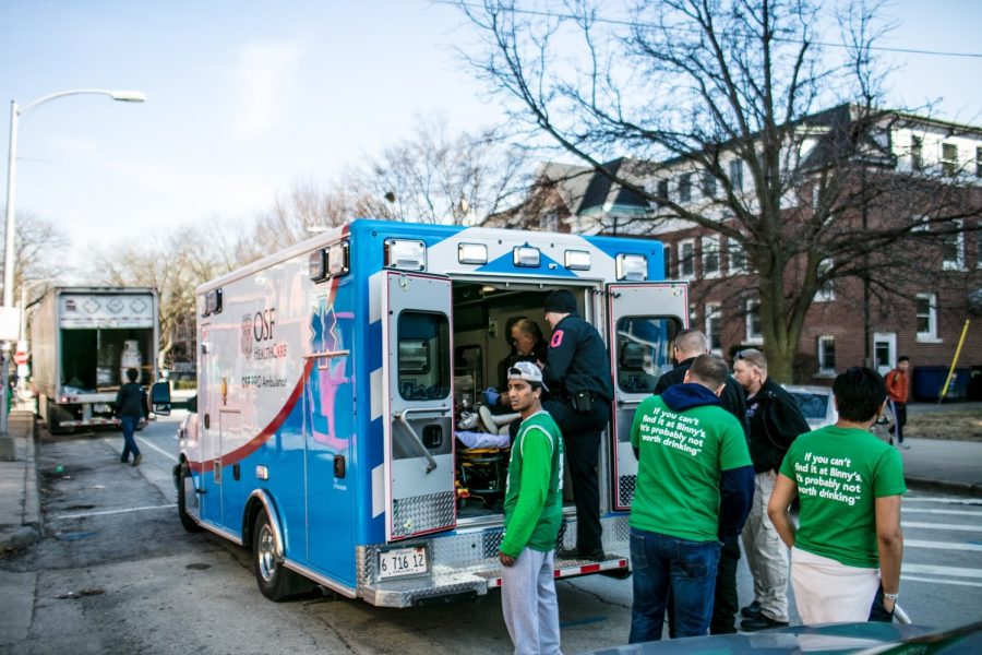 A participant of Unofficial stares at KAMs as his friend is taken into an OSF ambulance during Unofficial on March 1, 2019.