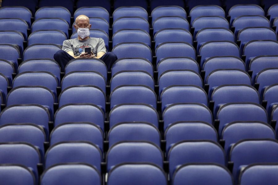 

Mike Lemcke, from Richmond, Va., sits in an empty Greensboro Coliseum after the NCAA college basketball games were cancelled at the Atlantic Coast Conference tournament in Greensboro, N.C., Thursday, March 12, 2020.
