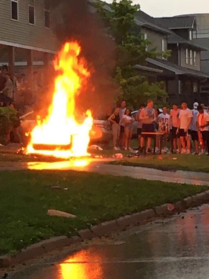 Students watch as a couch goes up in flames in Champaign on May 16.