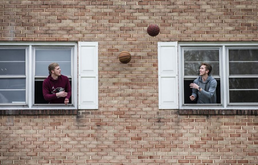Two college students make the most of quarantine by tossing a basketball back and forth through open windows on April 18, 2020 in Susquehanna, Pennsylvania. 