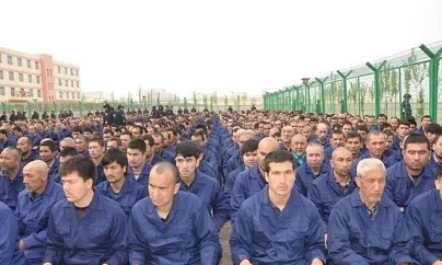 Detainees in a Xinjiang, China Re-education Camp located in Lop County listen to de-radicalization talks.
