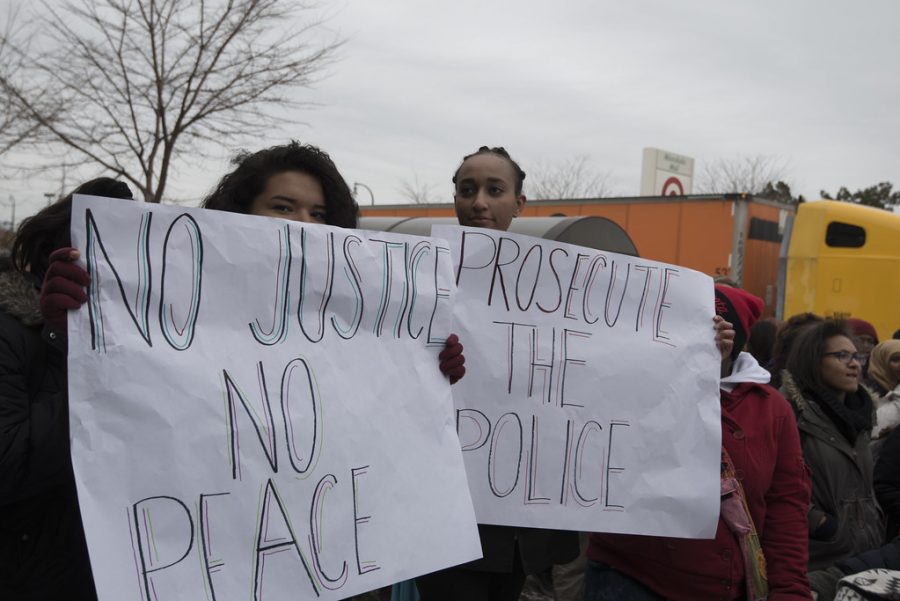 Protesters hold homemade signs at a demonstration following the death of George Floyd.