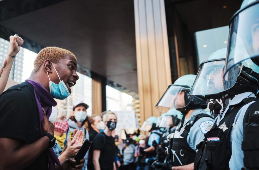 A line of protesters stand in front of police officers in downtown Chicago on Saturday.