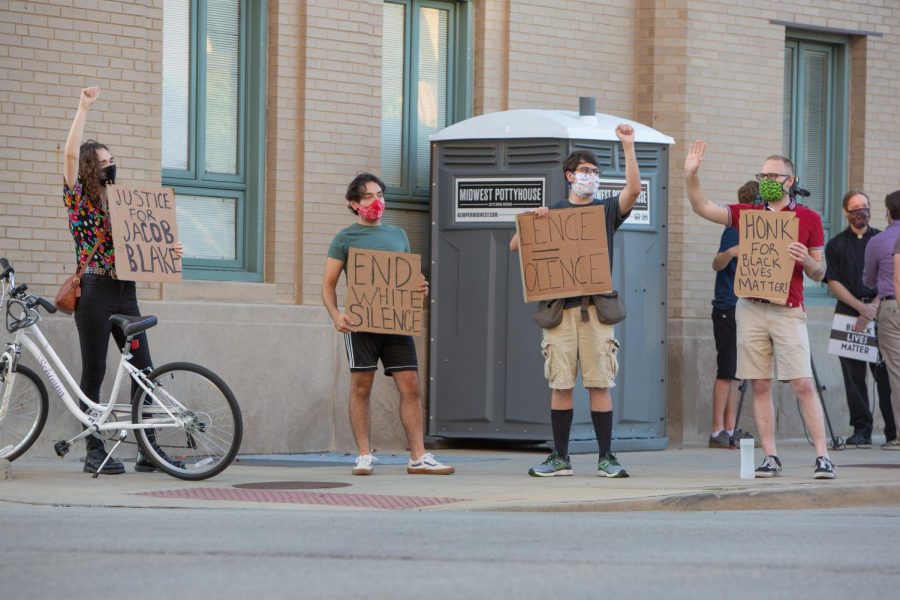 Demonstrators stand outside the Champaign City Building in Champaign, IL on the corner of University Ave and Walnut St in a show of support for Jacob Blake on Wednesday.