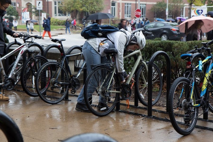A student unlocks their bike outside the English Building on Oct. 26, 2018. The University will soon be implementing a new bicycle registration database called 529 Garage.