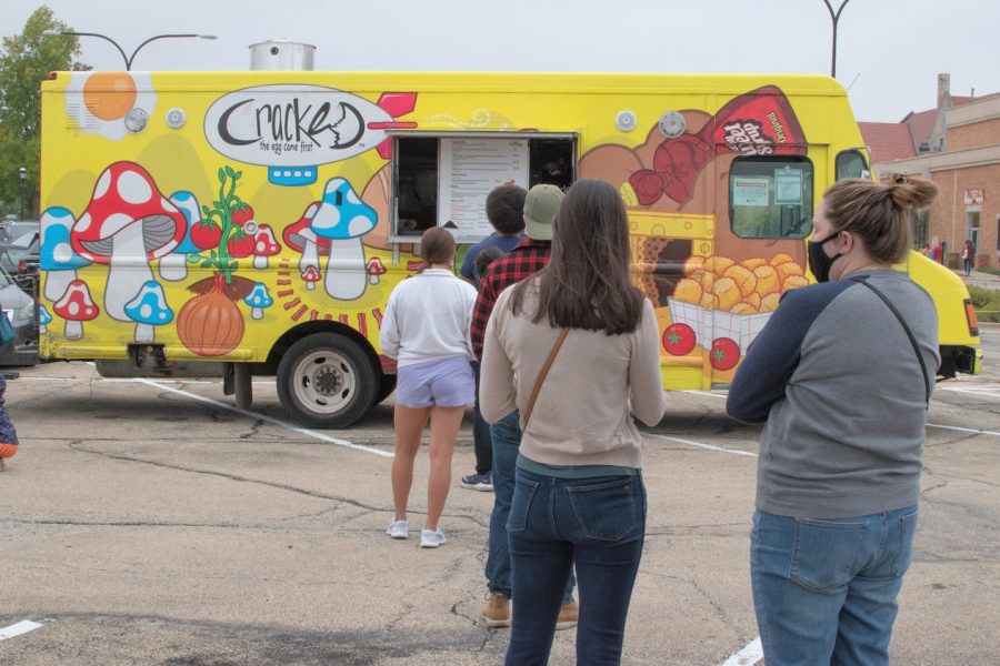 People wait in line to order at the Cracked the Egg Came First food truck at Lincoln Square Farmers Market in Urbana on Saturday.