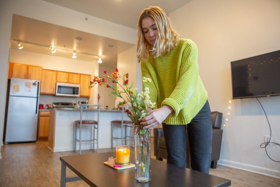 Sophomore Natalie Bizon adjusts the flowers in her apartment on Friday. Settling into your new housing is an important part of a new school year.