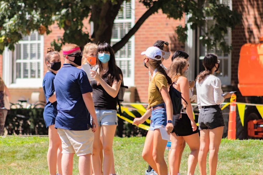 A group of students stands on the Main Quad while wearing masks on Aug. 21.