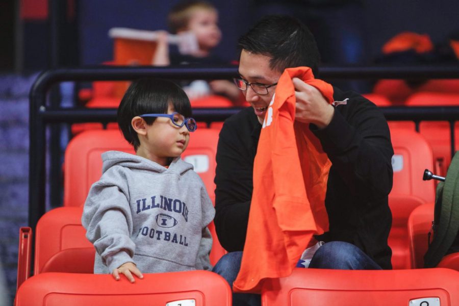 A father shows his son a t-shirt at the women’s basketball game against Indiana on Feb. 13. Columnist Marykate proposes parents take classes that teach them skills essential to raising a child.
