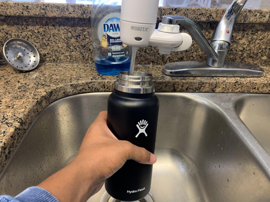 Brendyn Jones fills his water bottle from the filtered sink in his kitchen. Water filters are one of several necessary items new students shouldn’t forget.