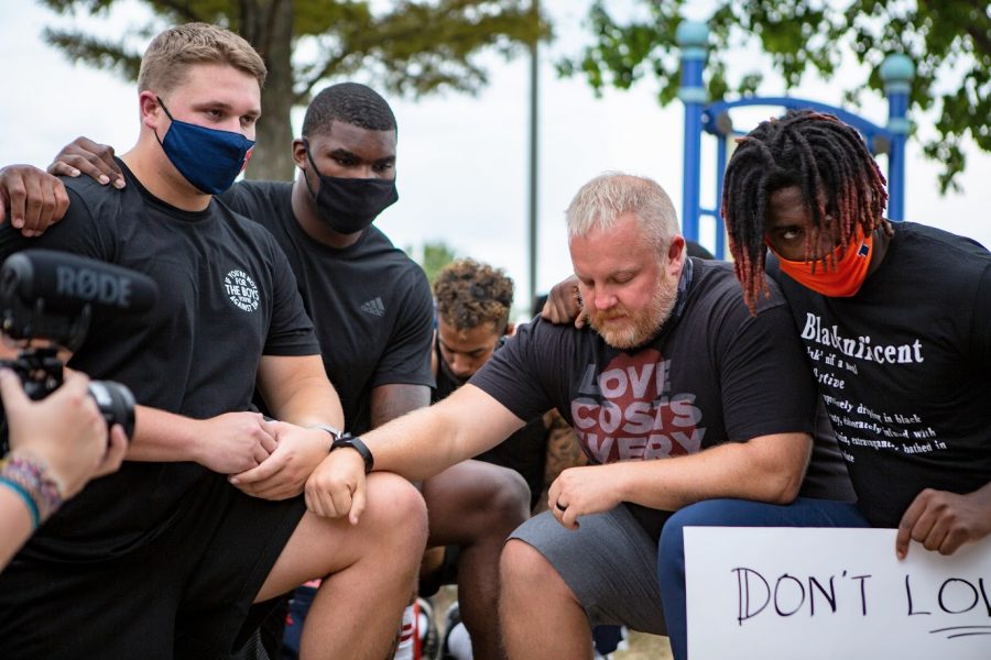 Illini football players Doug Kramer Jr., Owen Carney and Marquez Beason take a knee to honor those who have died at the hands of police during a Black Lives Matter protest on Aug 31. Hundreds of students and community members participated in local BLM protests this fall.