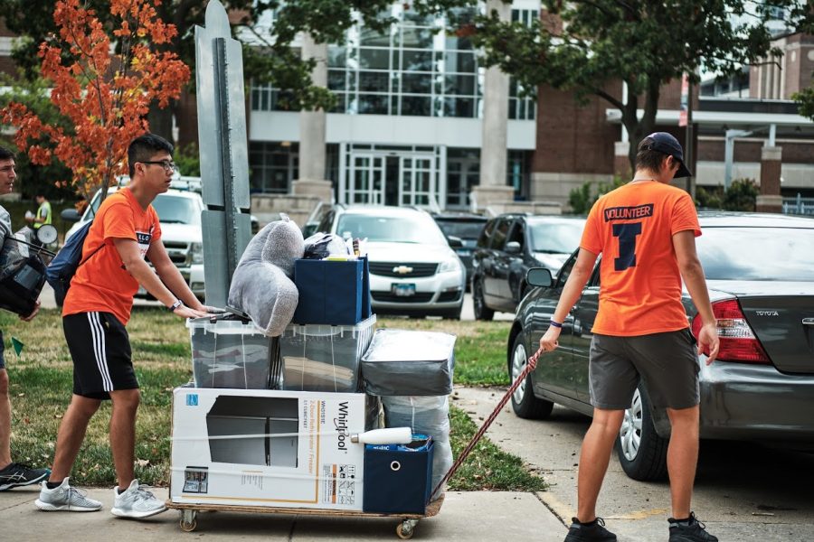 Two+I-Guides+assist+a+new+student+by+pushing+a+cart+loaded+with+their+items+during+move-in+on+Aug.+22%2C+2019.
