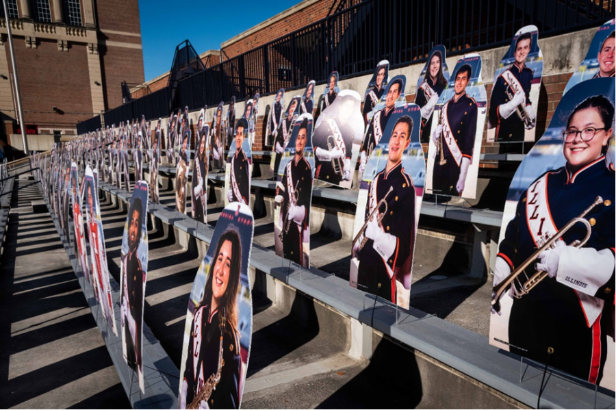 The Marching Illinis cardboard cutouts sit on the bleachers of Memorial Stadium. Home games are treated with pre-recorded tapes of the bands music. 