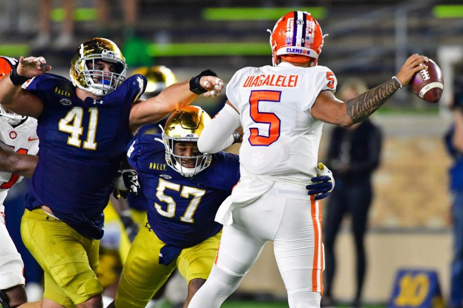 Notre Dame defensive linemen Kurt Hinish (41) and Jayson Ademilola (57) pressure Clemson quarterback D.J. Uiagalelei (5) in the third quarter at Notre Dame Stadium in South Bend, Indiana, on Saturday. Notre Dame won, 47-40, in double overtime.