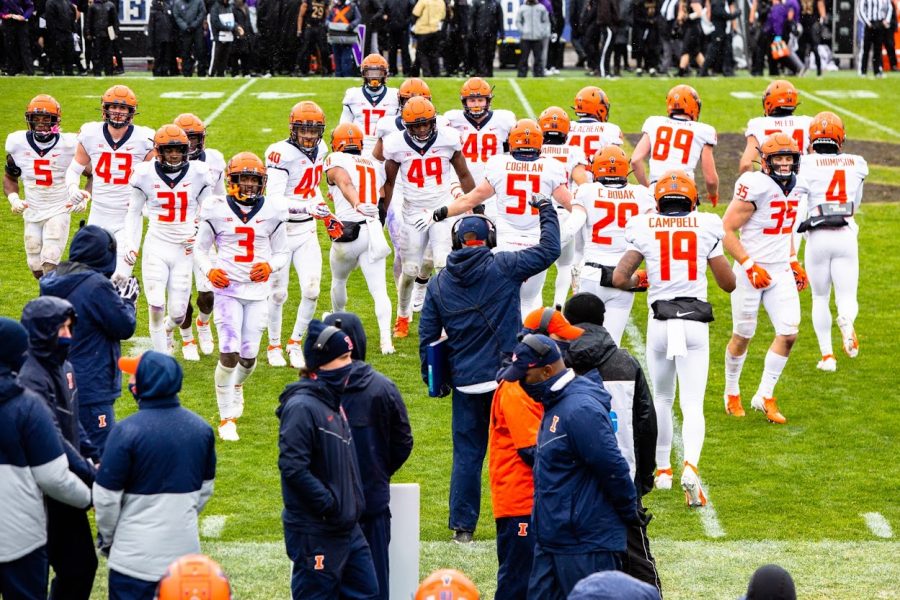 Players of the Illinois football team enter and exit the field between plays during the game against Northwestern on Saturday. The Illini lost the game 28-10.