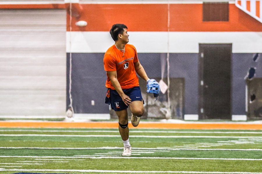 Infielder Branden Comia runs back for a catch during practice on Jan. 14 at the Fighting Illini indoor training facility. 