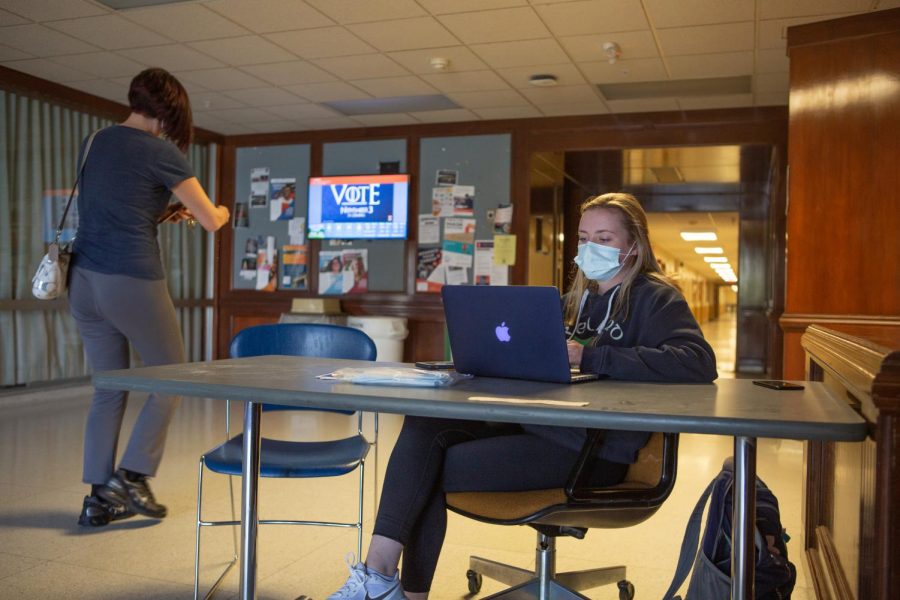 A University Wellness Associate checks a woman into Bevier Hall on Oct. 14. Students and faculty are unable to enter University buildings without building access being granted through the Safer Illinois application.