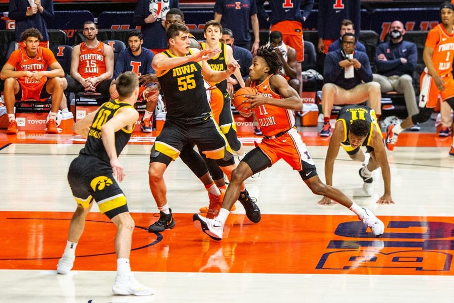 Iowa senior center Luke Garza attempts to defend as junior guard Ayo Dosunmu drives through the lane during the game between Illinois and Iowa on Jan. 29 at State Farm Center. Dosunmu and Garza are the front runners for the Big Ten Player of the Year award.