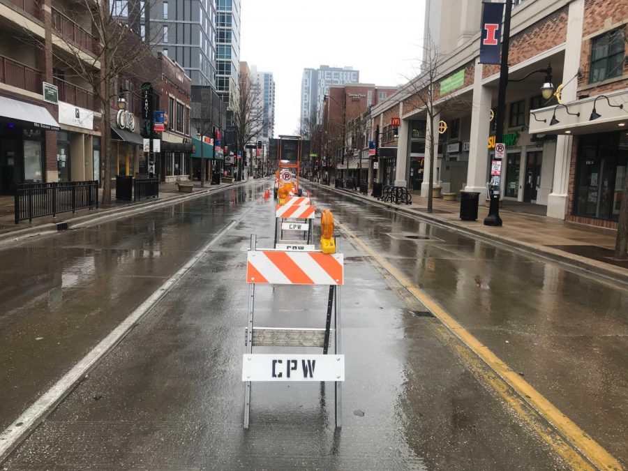 Road barricades sit on the middle lane all down Green Street. The City of Champaign has implemented new rules to prevent illegal parking on the street.