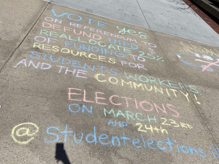 University students denounce the University of lllinois’s Police Department in chalk in front of the Union on March 20. This past week, students had the ability to vote for reallocating part of the UIPD’s budget toward other more worthy resources. 