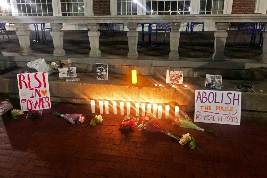 Photos, candles, flowers and posters are placed on a bench in front of the Illini Union to honor the late Daunte Wright. The vigil was held by University students to honor victims of police brutality.