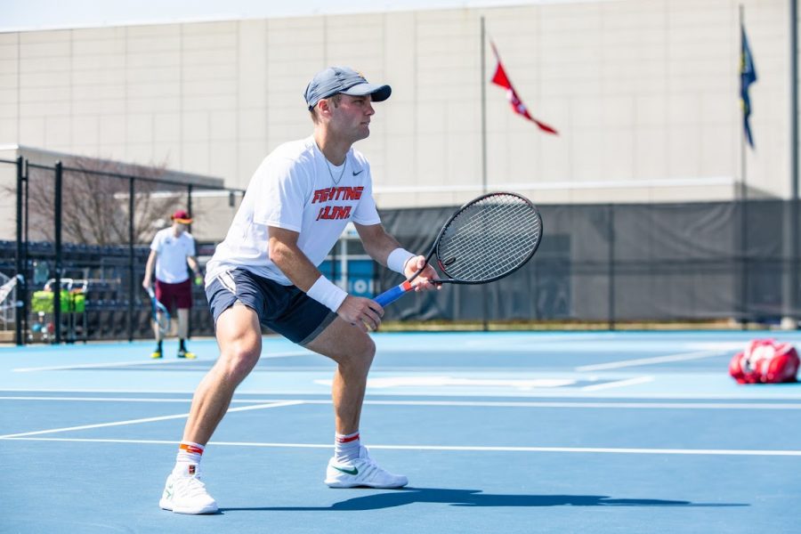 Senior Zeke Clark waits for the serve during the match against Minnesota April 4. Clark recently secured his 100th career singles victory, becoming the 16th player in program history to reach that mark.