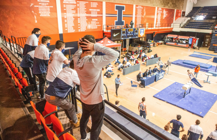 Non-competing members of the Illinois men’s gymnastics team cheer while overlooking a teammate on the pommel horse in a meet against Ohio State Jan. 23. The team is set to compete in Lincoln, Nebraska, this weekend for the Big Ten Championships despite multiple gymnasts being injured. 