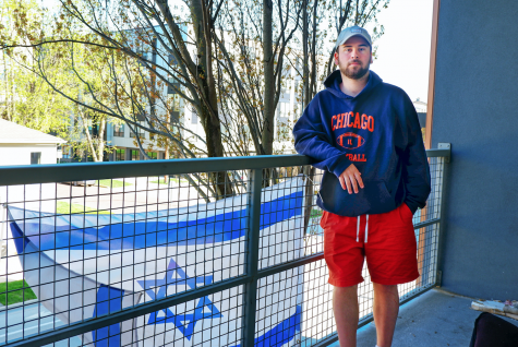 Jeremy Zelner, senior in LAS, poses for a photo on his balcony in front of his Israeli flag on April 14. Zelner is one of the many victims on campus to have experienced anti-Semitism.